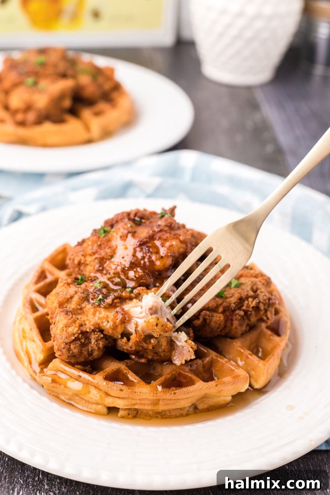 Southern Fried Bliss 17 A fork taking a delicious bite of Chicken and Waffles, showcasing the crispy chicken and fluffy waffle