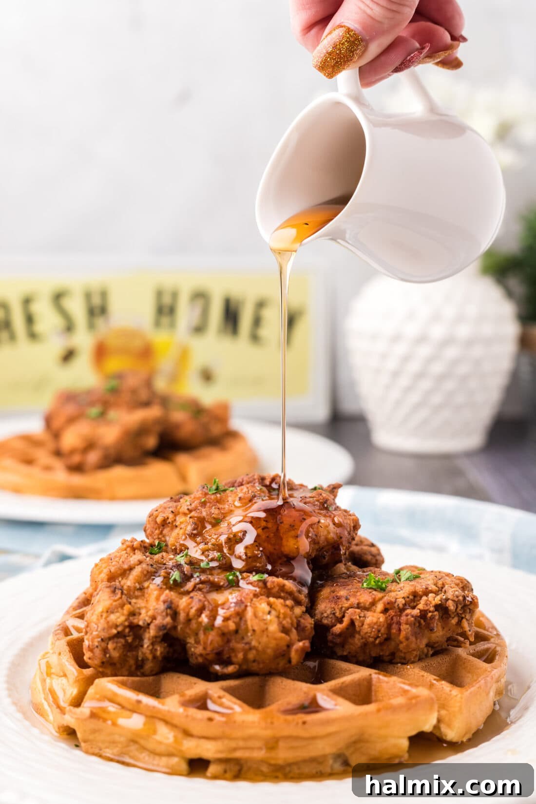Southern Fried Bliss 3 Syrup being generously drizzled over a plate of freshly made Chicken and Waffles