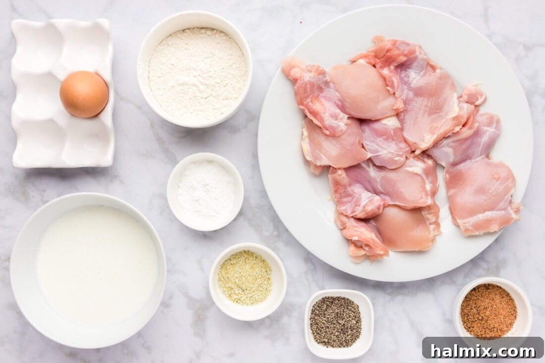 Southern Fried Bliss 4 A selection of fresh ingredients laid out for making Chicken and Waffles, including chicken thighs, flour, eggs, buttermilk, and spices