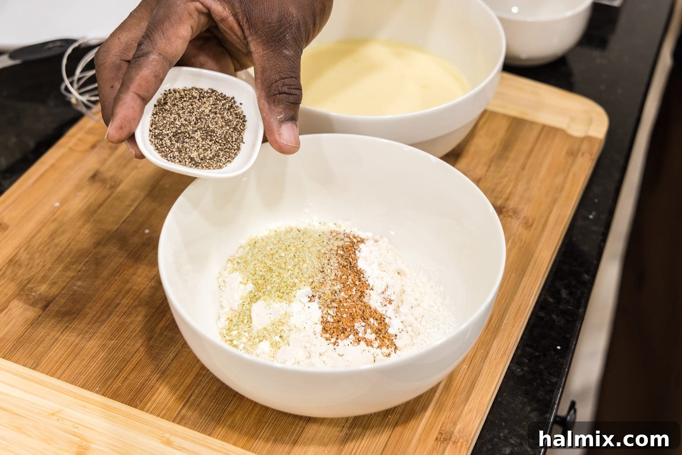 Southern Fried Bliss 6 Adding black pepper to the flour and spice mixture in a bowl