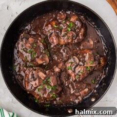Close-up of Veal Marsala in a skillet, showcasing the rich sauce and tender meat