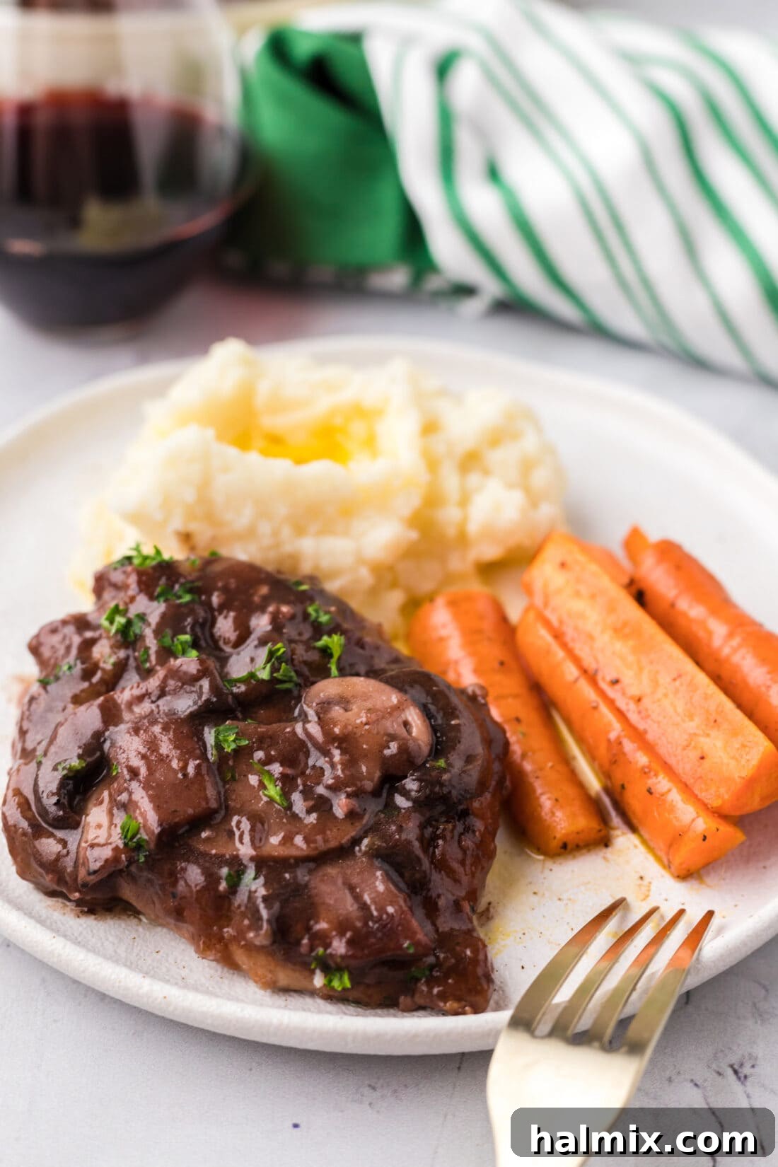 Marsala Veal: Italian Elegance 3 Plated Veal Marsala served alongside creamy mashed potatoes and vibrant glazed carrots, a complete gourmet meal