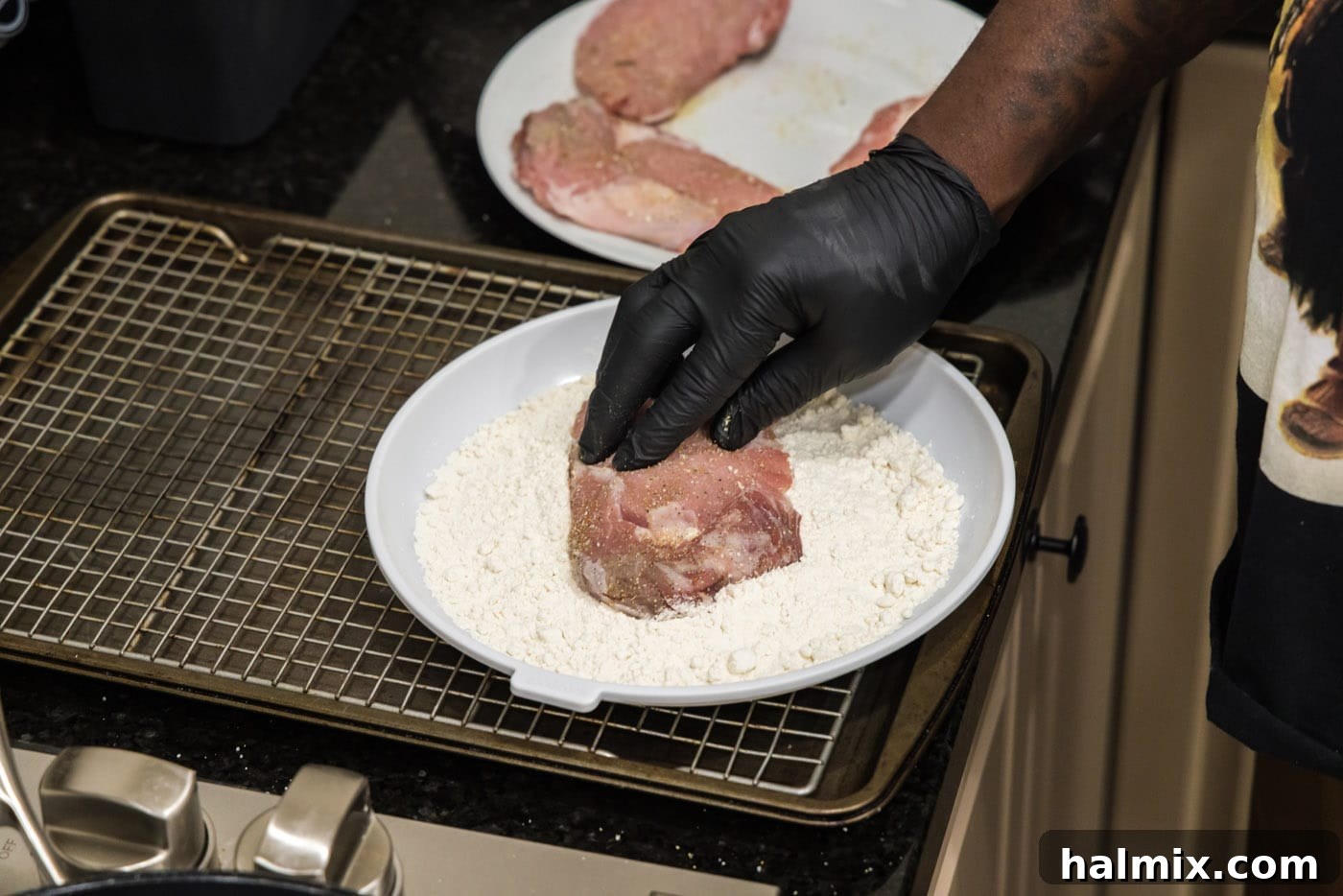 Marsala Veal: Italian Elegance 5 A chef gently pressing a veal chop into a shallow plate of flour to coat it evenly