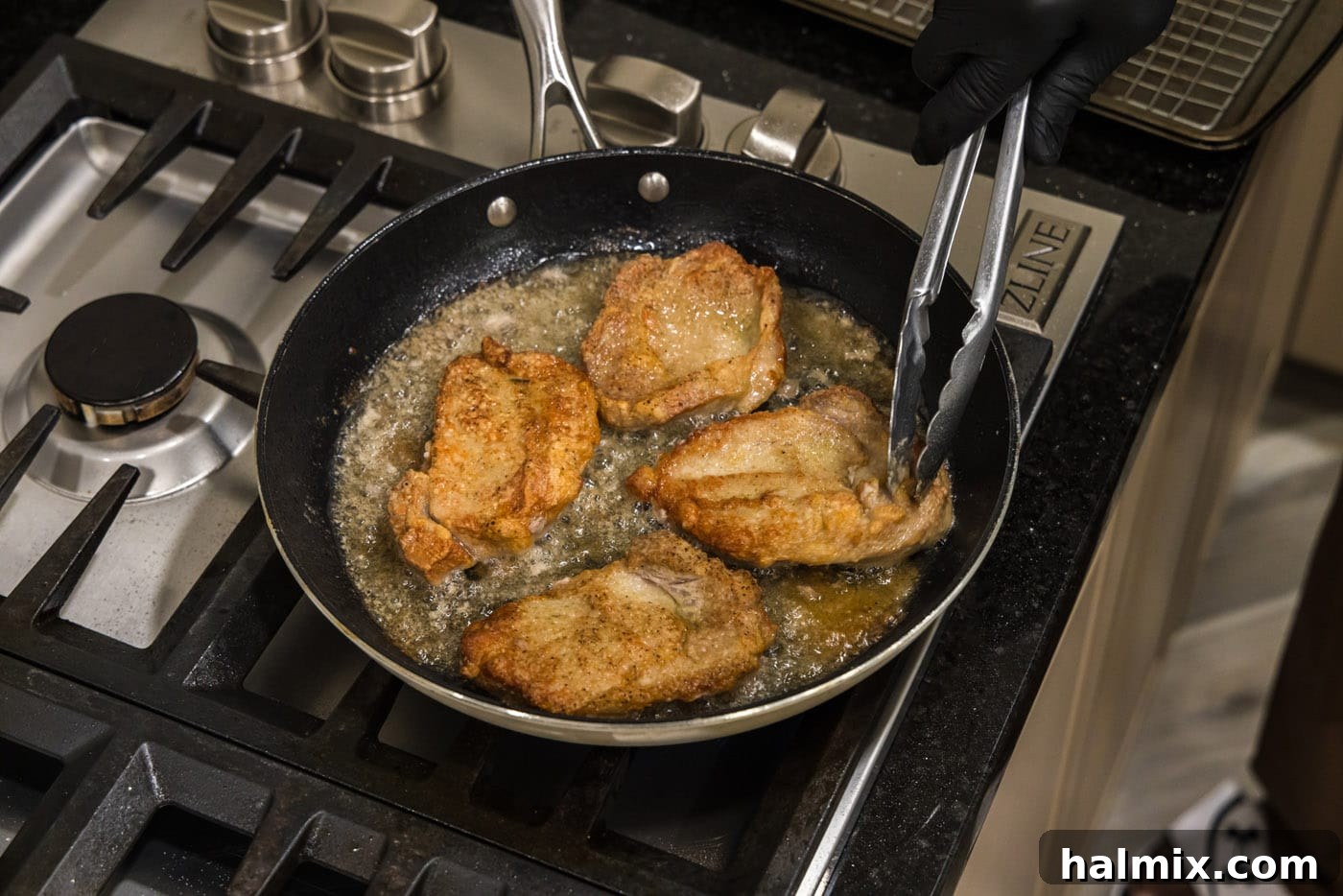 Marsala Veal: Italian Elegance 8 Using kitchen tongs to carefully flip veal chops in a hot skillet, revealing a perfectly seared side