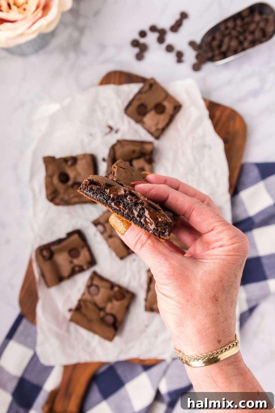 Hand holding half of a Cake Mix Brownie, showing its delicious interior