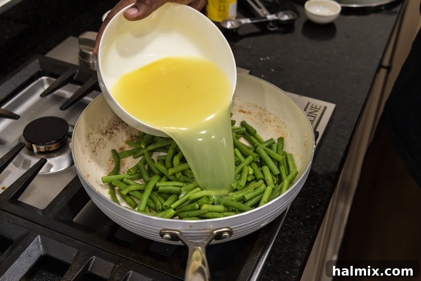 Old Fashioned Southern Green Beans 8 Pouring chicken stock into a skillet with fresh green beans