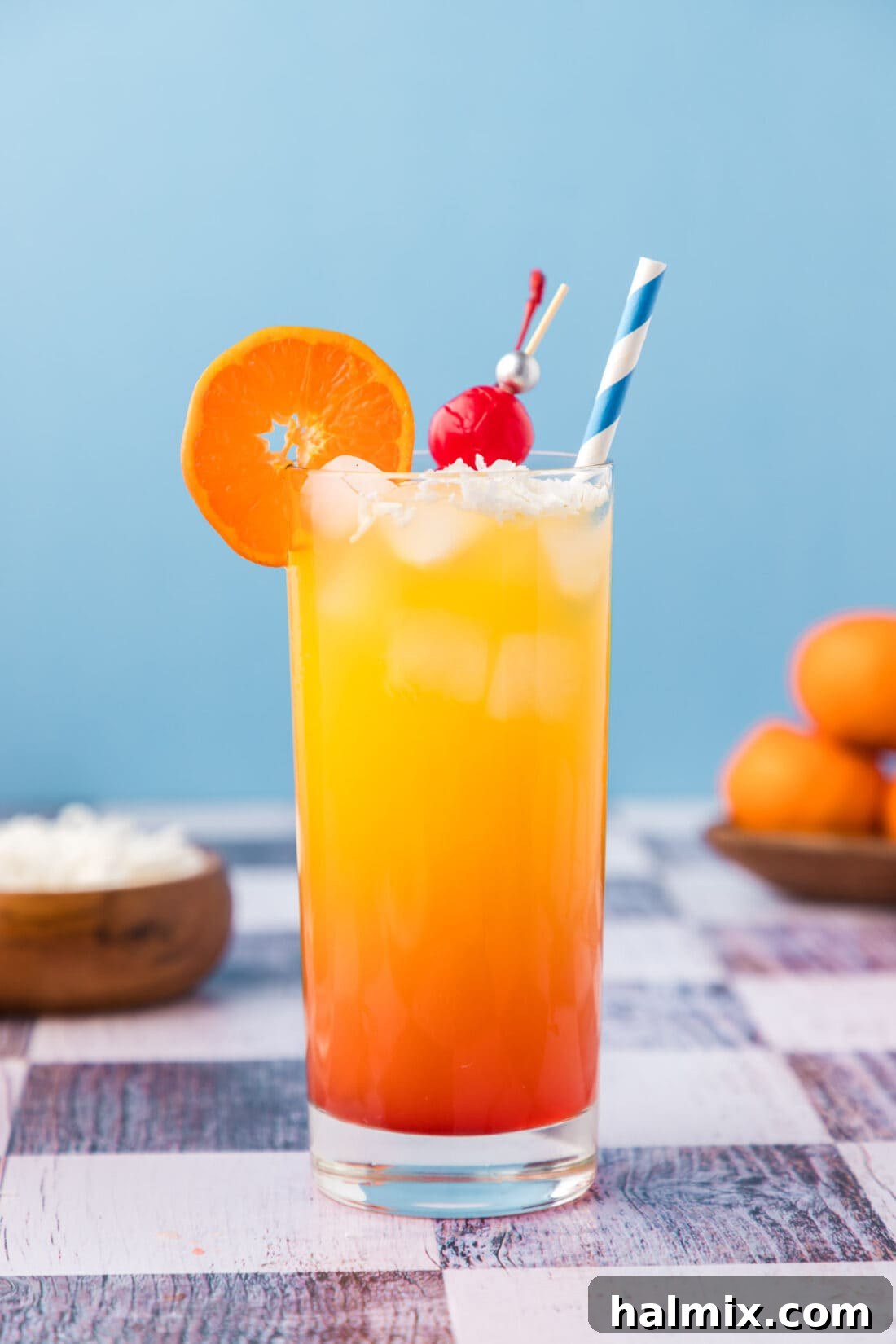 Delicious Malibu Sunrise cocktail with orange and cherry garnish, vibrant colors.