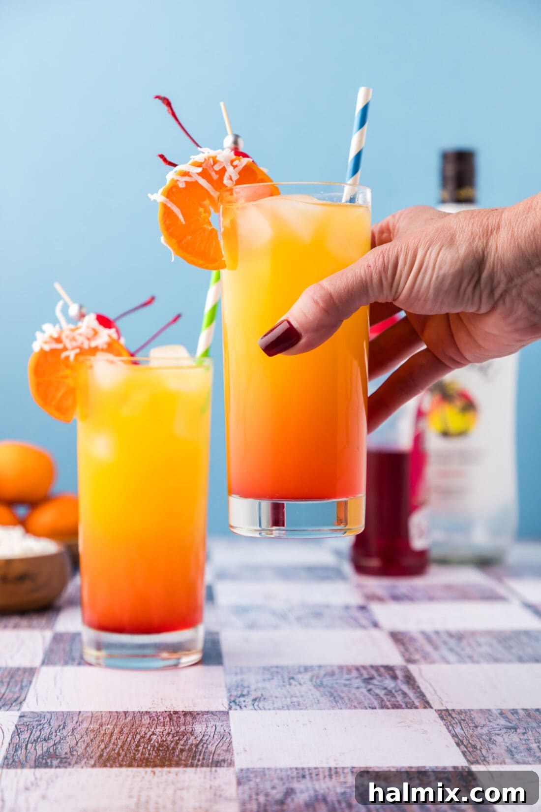 Enjoying a refreshing Malibu Sunrise cocktail outdoors, perfect for a sunny day.