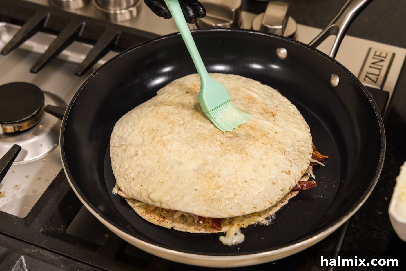 Crispy Ranch Chicken Bacon Quesadillas 16 Brushing the top tortilla with melted butter while the quesadilla cooks in the skillet.