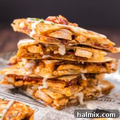 Close up photo of a stack of Chicken Bacon Ranch Quesadilla triangles, ready to be eaten.