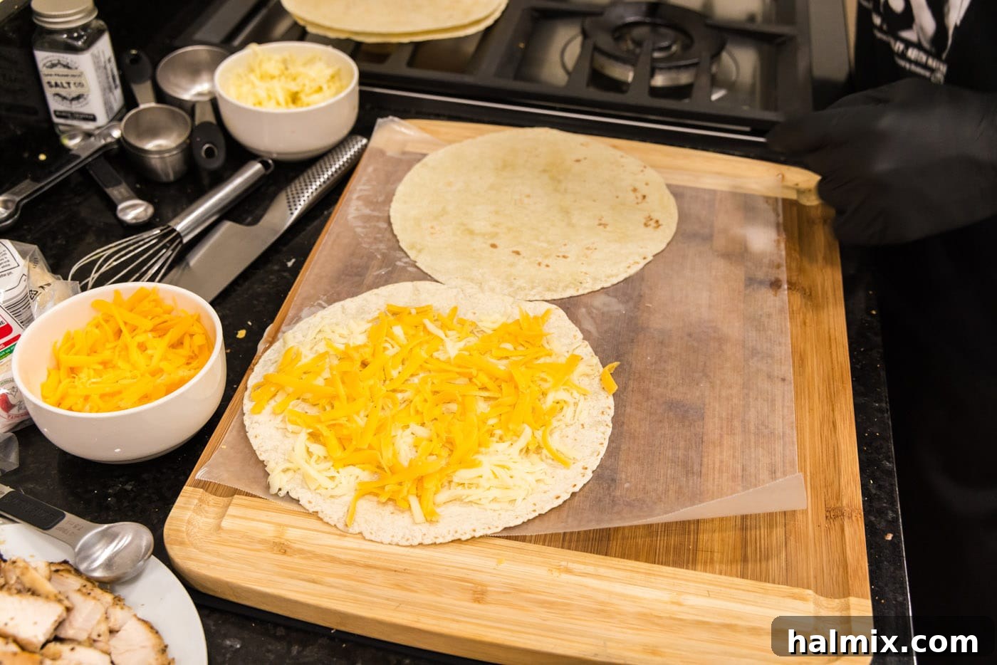 Crispy Ranch Chicken Bacon Quesadillas 7 Close-up of cheddar and mozzarella cheese evenly spread on a tortilla.