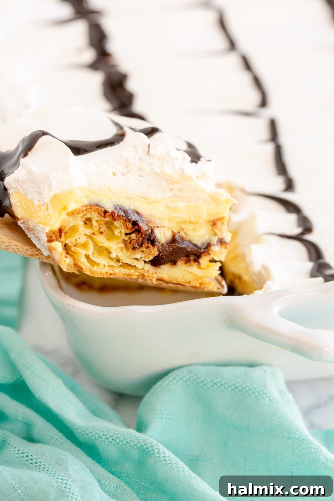 Chocolate Eclair Cloud Cake 2 removing a slice of Cream Puff Chocolate Eclair Cake from pan