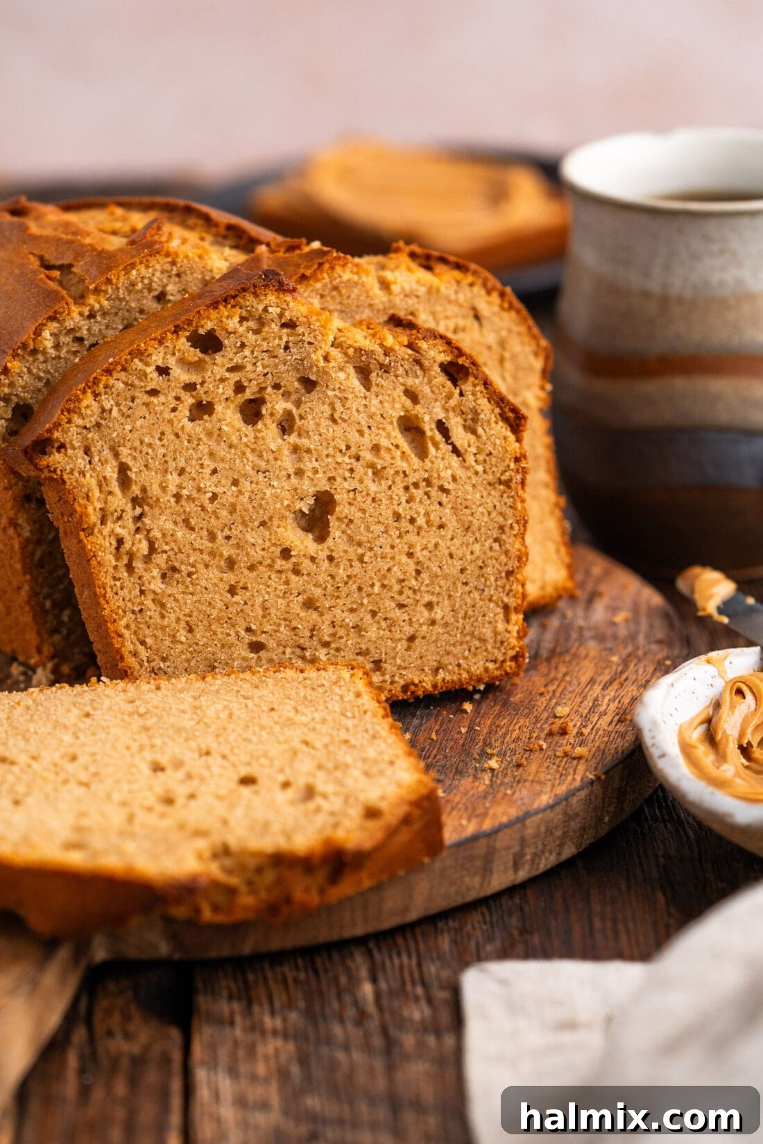 Close-up side view of a thick slice of moist Peanut Butter Bread, showing its texture.