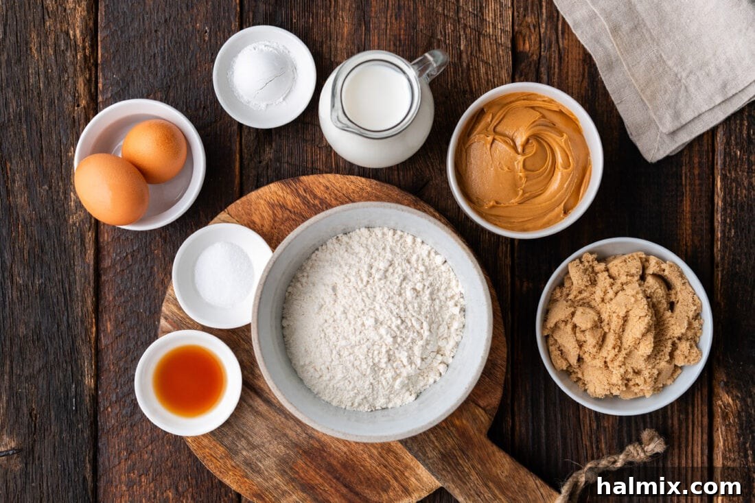 A collection of ingredients for Peanut Butter Bread, including flour, sugar, eggs, milk, vanilla, and a jar of peanut butter, laid out on a kitchen counter.