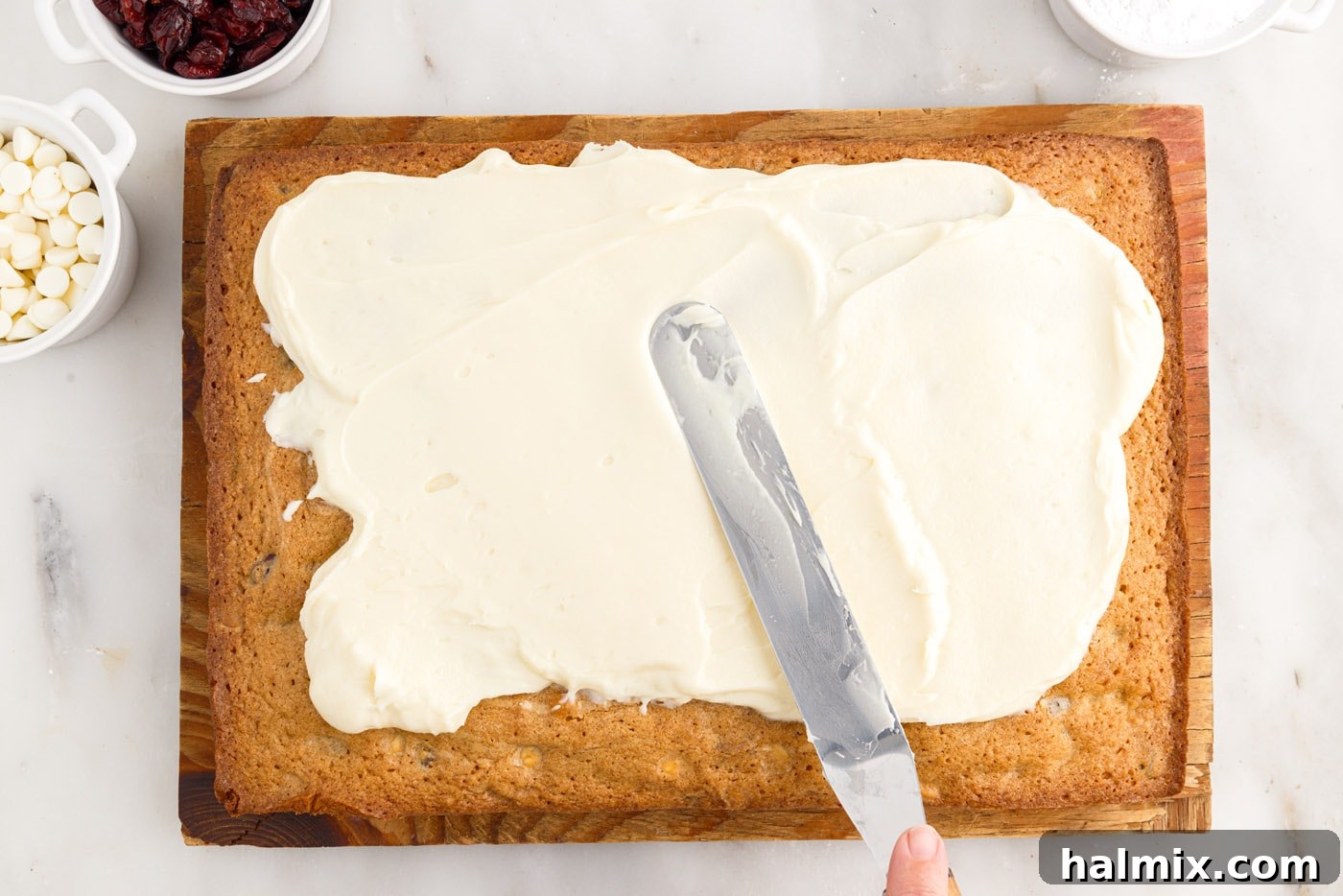 Tangy Cranberry Dream Bars 15 spreading cream cheese frosting over baked blondies