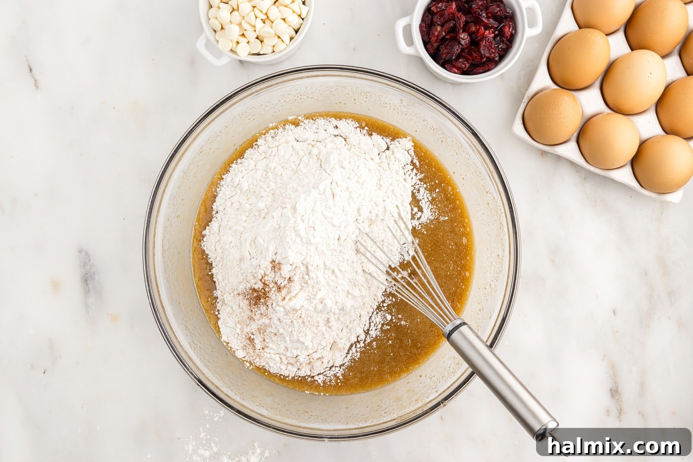 Tangy Cranberry Dream Bars 7 whisking flour into butter and sugar mixture in a bowl