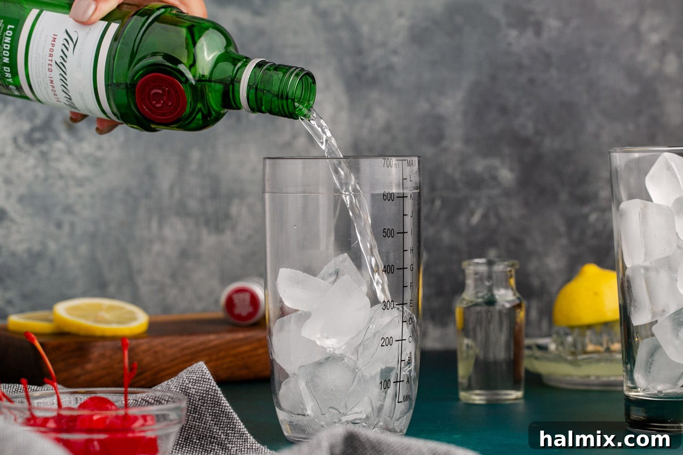 pouring gin into cocktail shaker with ice