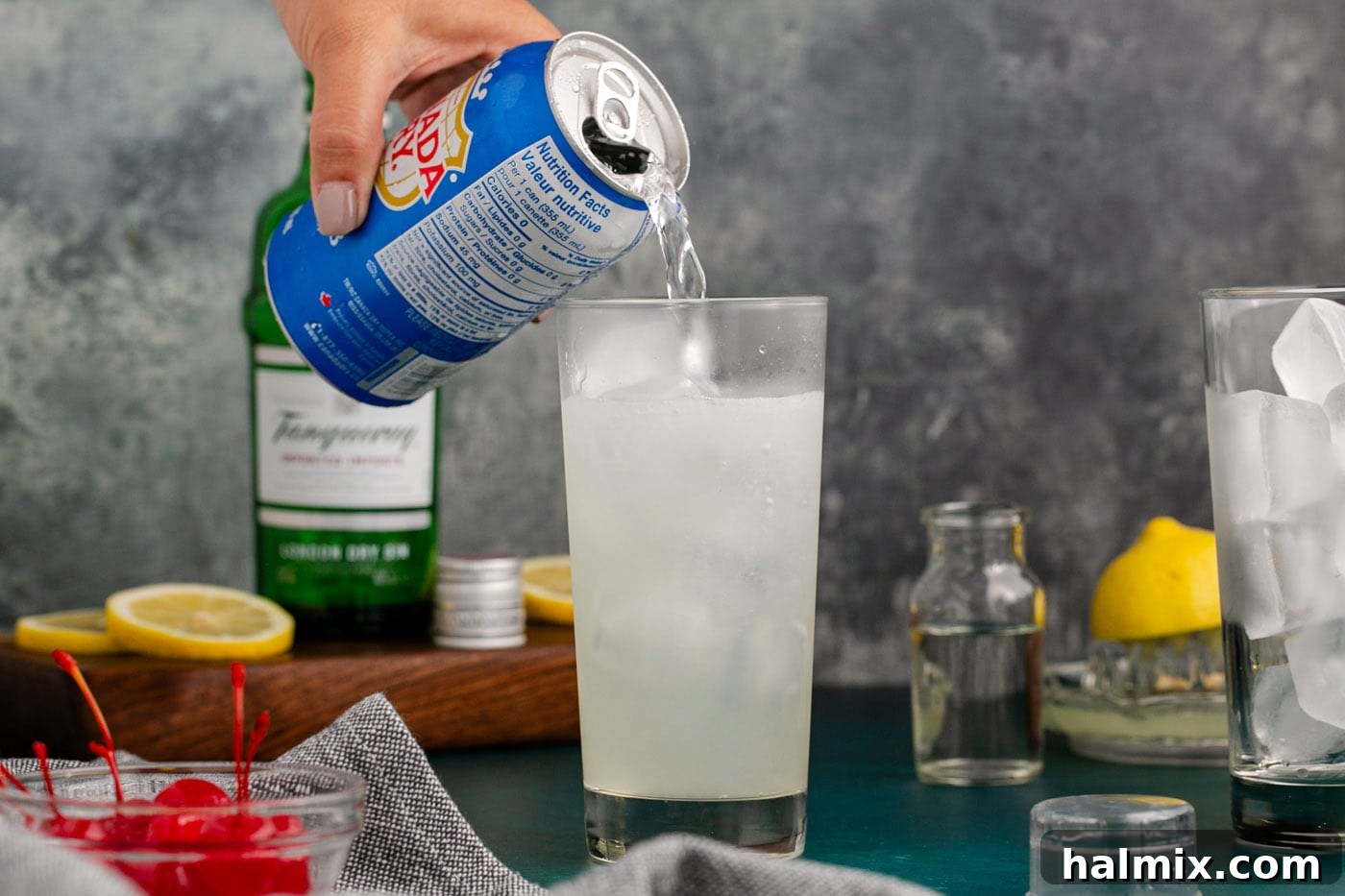 pouring club soda over tom collins