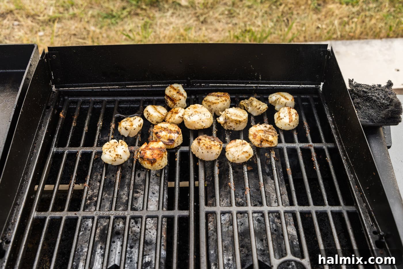 Scallops being flipped on the grill, showing a perfect sear