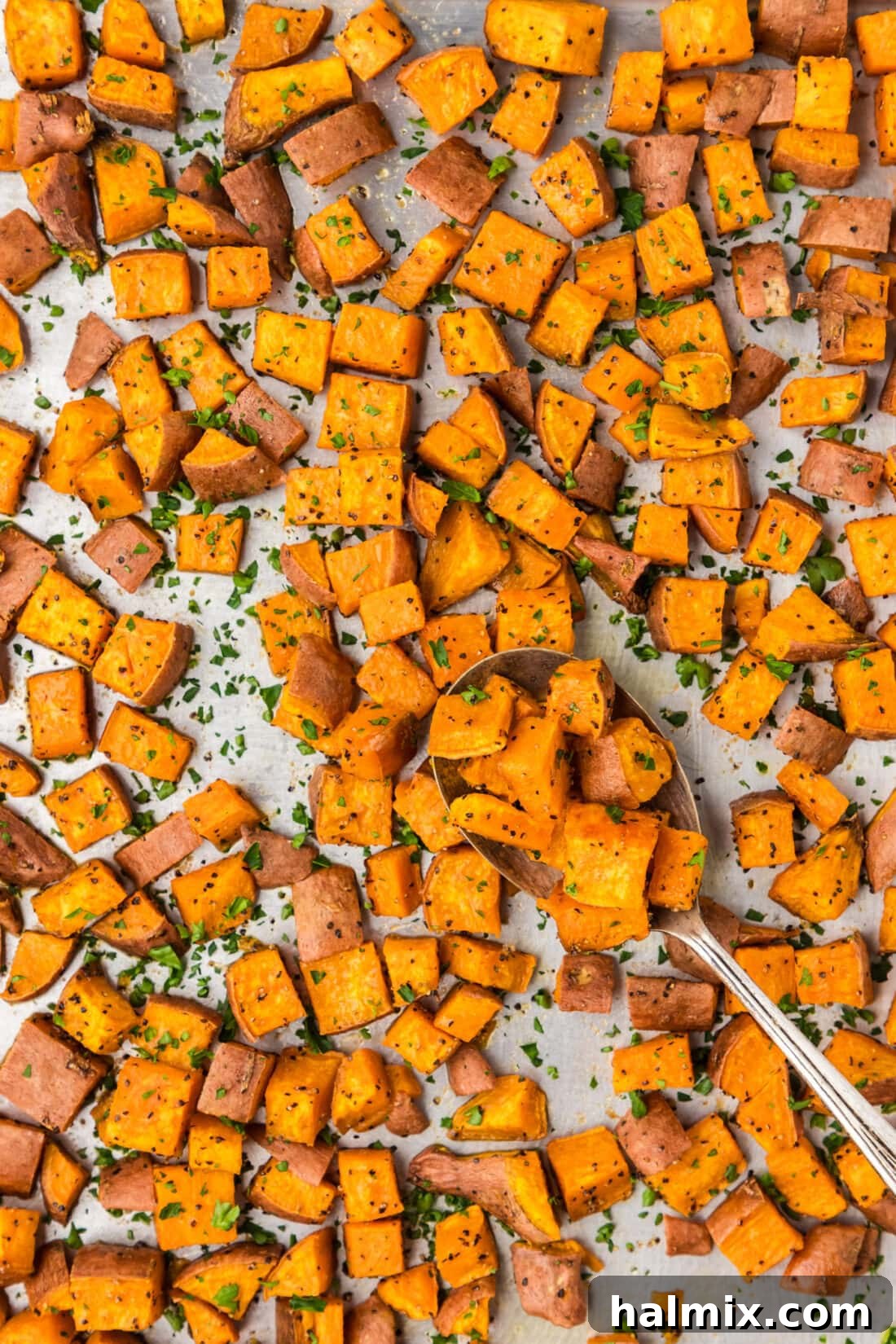 Caramelized Sweet Potatoes 2 Sheet pan of Roasted Sweet Potatoes with a spoon on the sheet pan