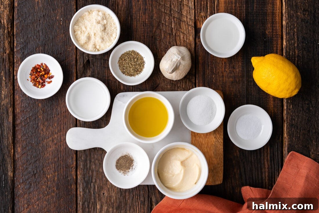 Fresh ingredients for Homemade Garlic Parmesan Wing Sauce laid out on a wooden board