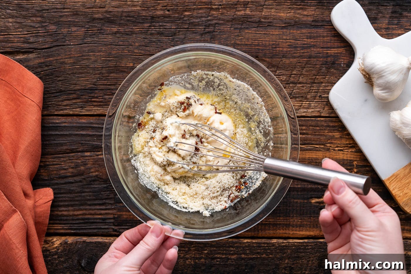 Mixing all ingredients for creamy garlic parmesan wing sauce in a medium bowl