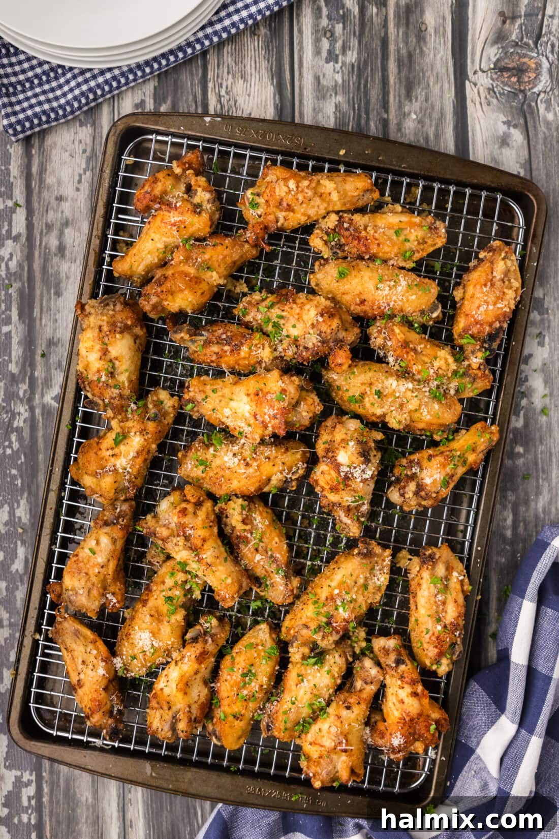 Crispy Garlic Parmesan Wings 2 Garlic Parmesan Wings resting on a wire rack