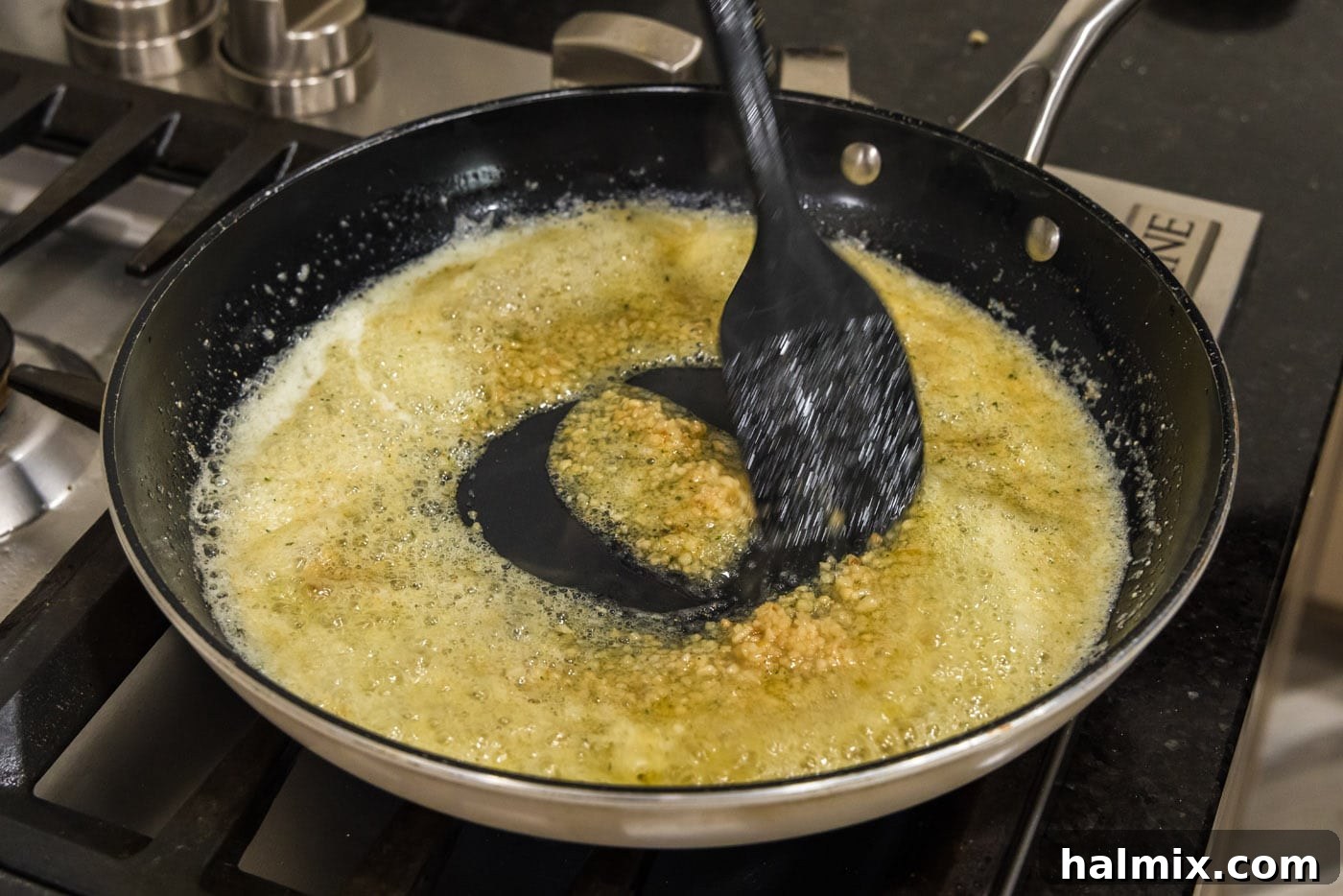 Crispy Garlic Parmesan Wings 11 stirring minced garlic into seasoned butter ina skillet