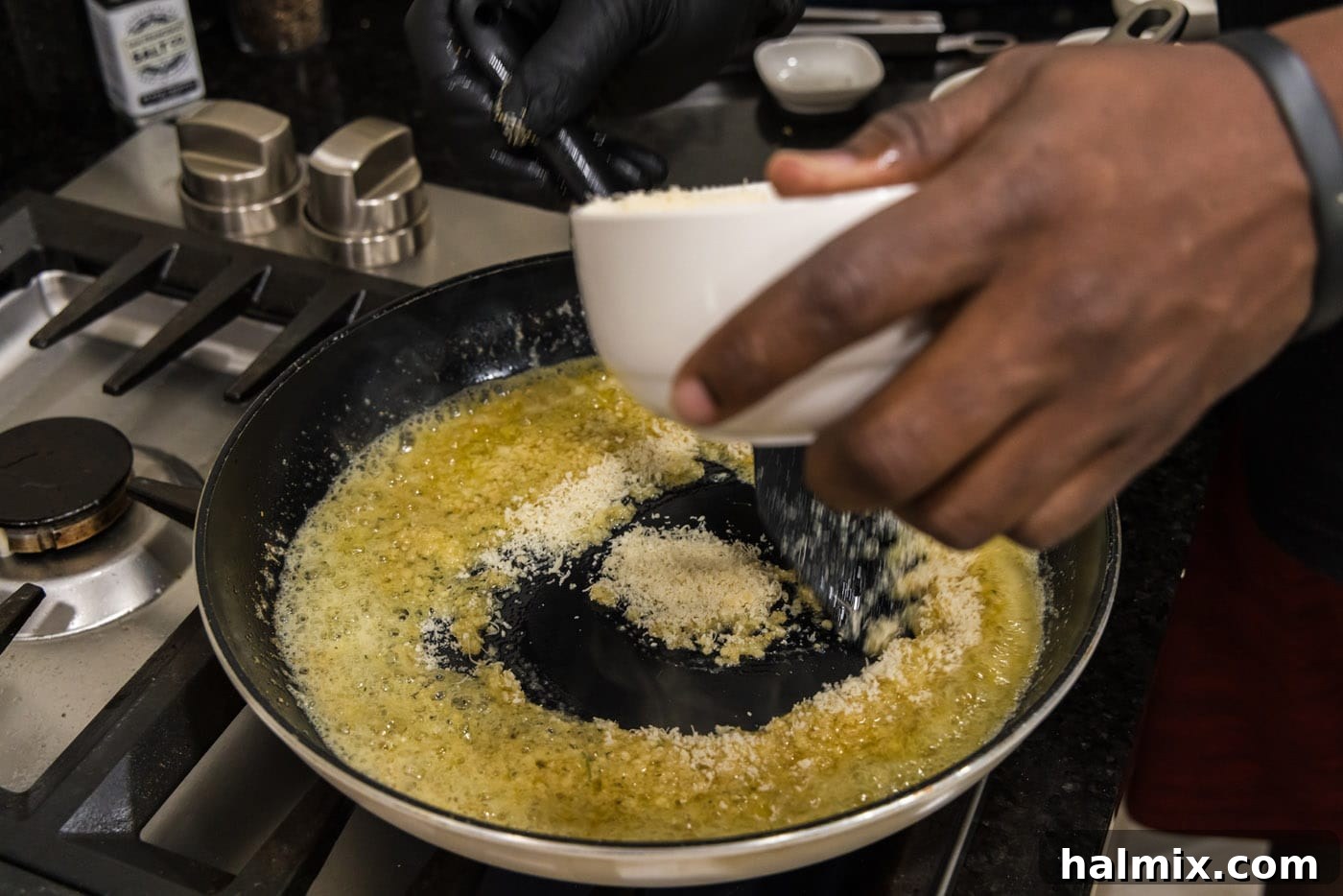 Crispy Garlic Parmesan Wings 12 adding parmesan cheese to butter and garlic mixture in a skillet