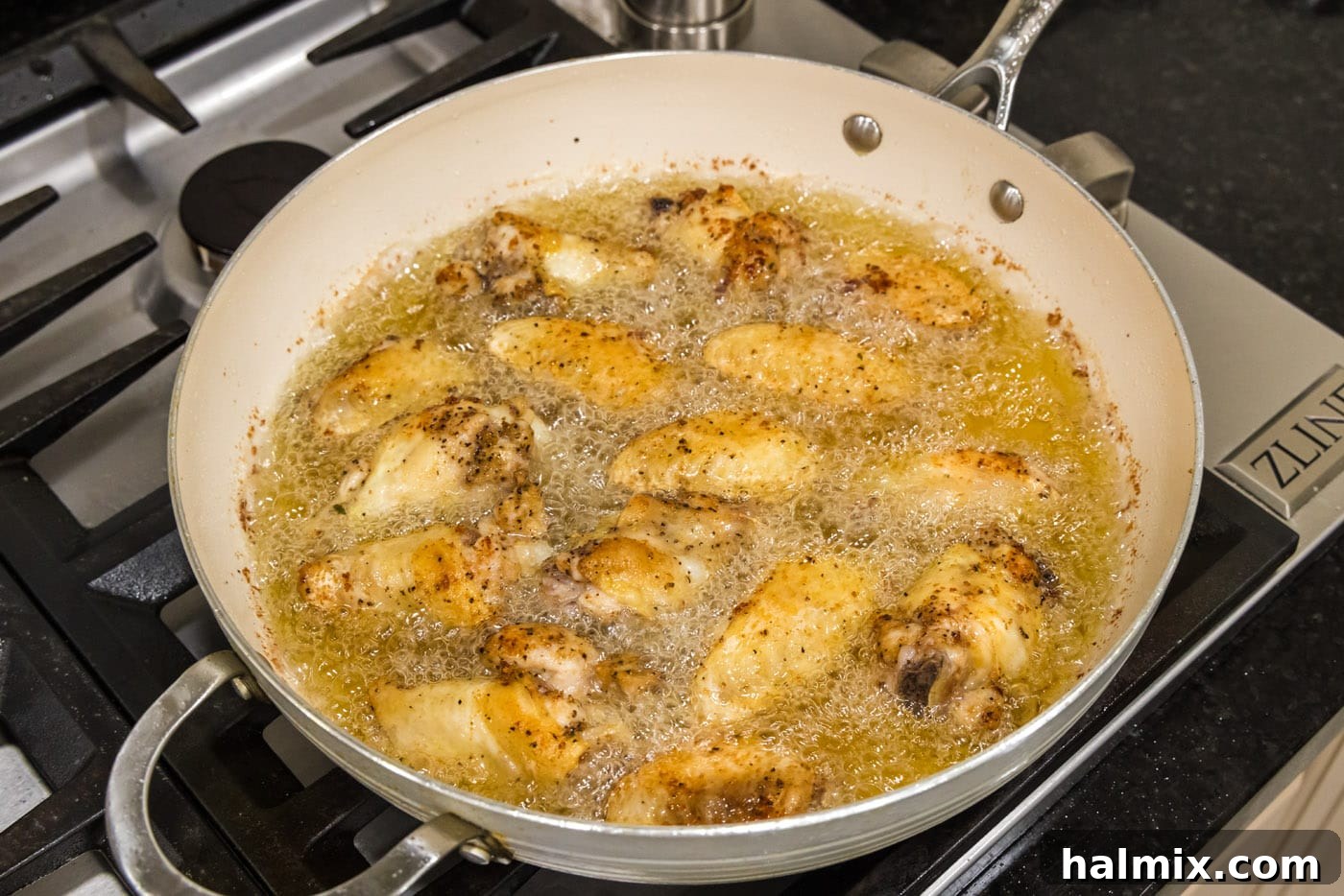 Crispy Garlic Parmesan Wings 8 frying chicken wings in a skillet of oil
