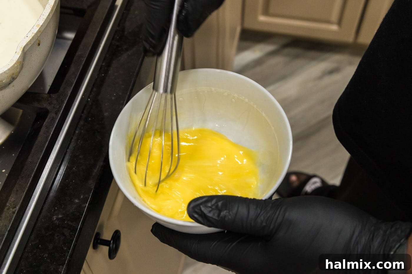 Creamy Chicken and Shrimp Carbonara 11 Whisking eggs in a medium bowl, preparing them for tempering into the carbonara sauce.