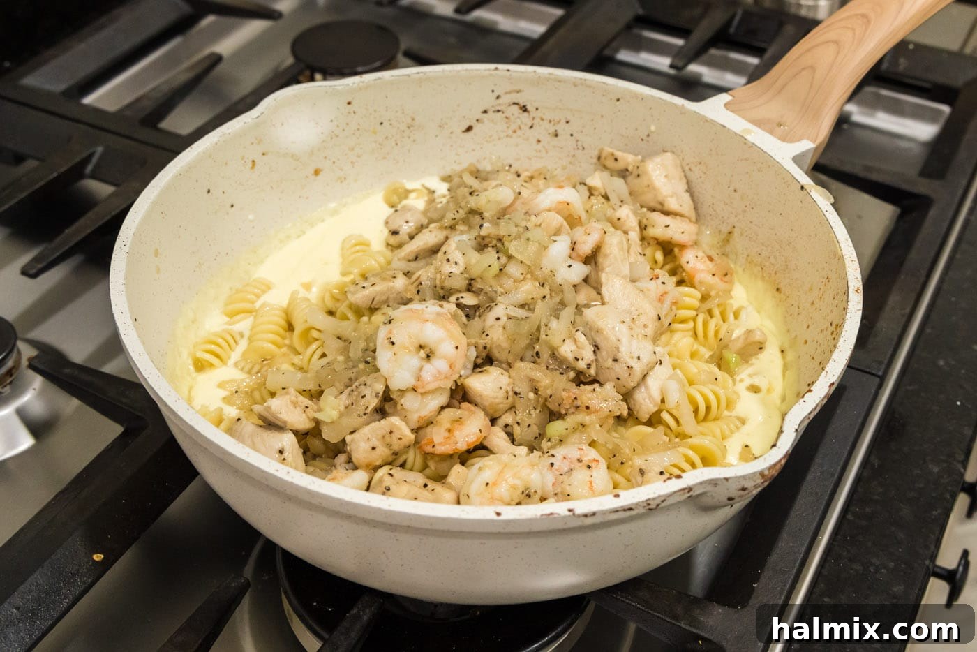 Creamy Chicken and Shrimp Carbonara 14 Adding the cooked chicken and shrimp mixture back into the skillet with the pasta and creamy carbonara sauce, ready to be combined.