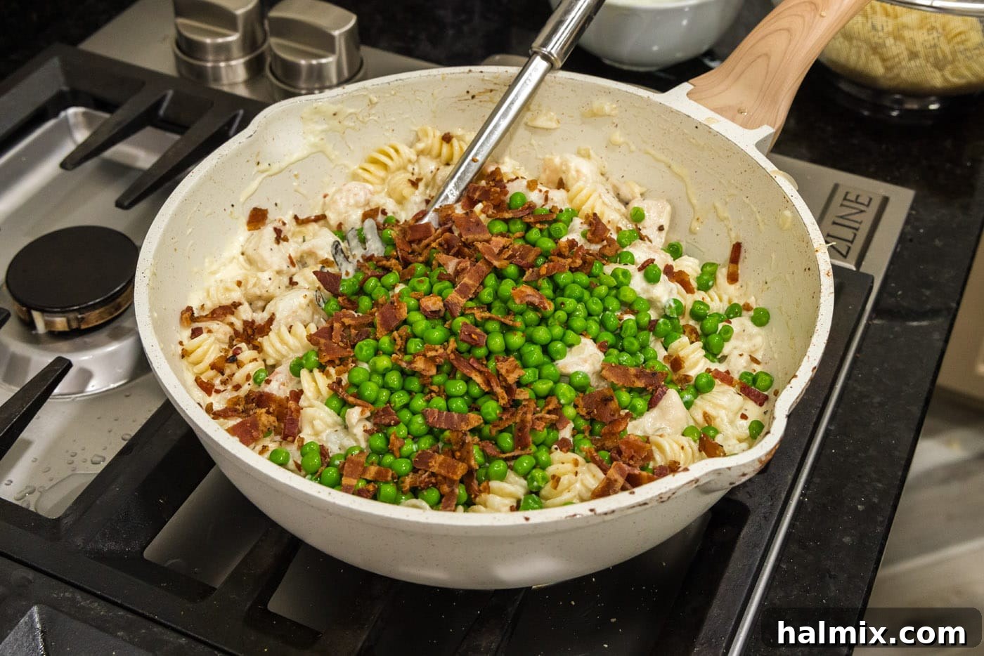 Creamy Chicken and Shrimp Carbonara 15 Adding fresh peas and crispy bacon bits to the chicken and shrimp carbonara in the skillet for final heating and serving.
