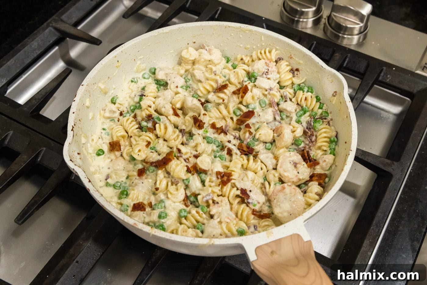 Creamy Chicken and Shrimp Carbonara 16 A beautifully presented skillet of Chicken and Shrimp Carbonara, complete with golden pasta, savory proteins, vibrant peas, and crispy bacon.