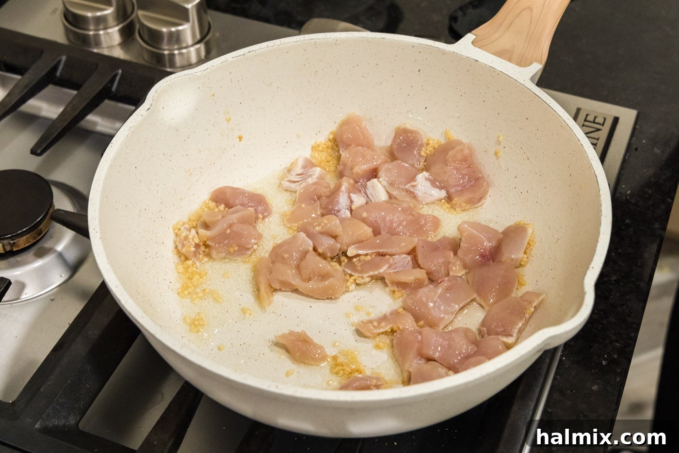 Creamy Chicken and Shrimp Carbonara 5 Chicken chunks cooking in a skillet with olive oil and garlic.