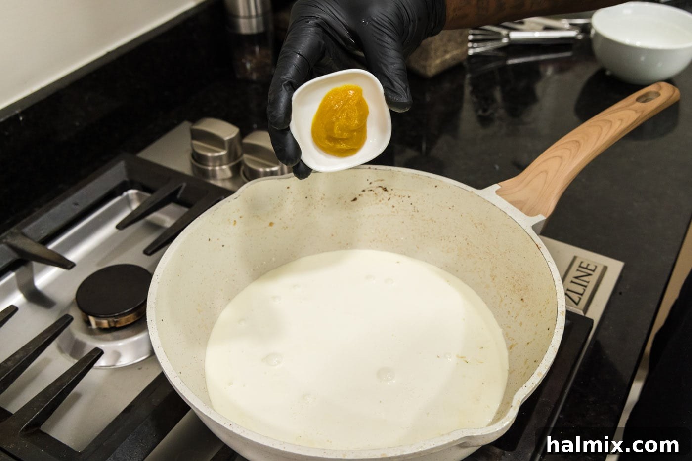Creamy Chicken and Shrimp Carbonara 10 Adding chicken base or bouillon to the heavy cream in the skillet, ready to be whisked in.
