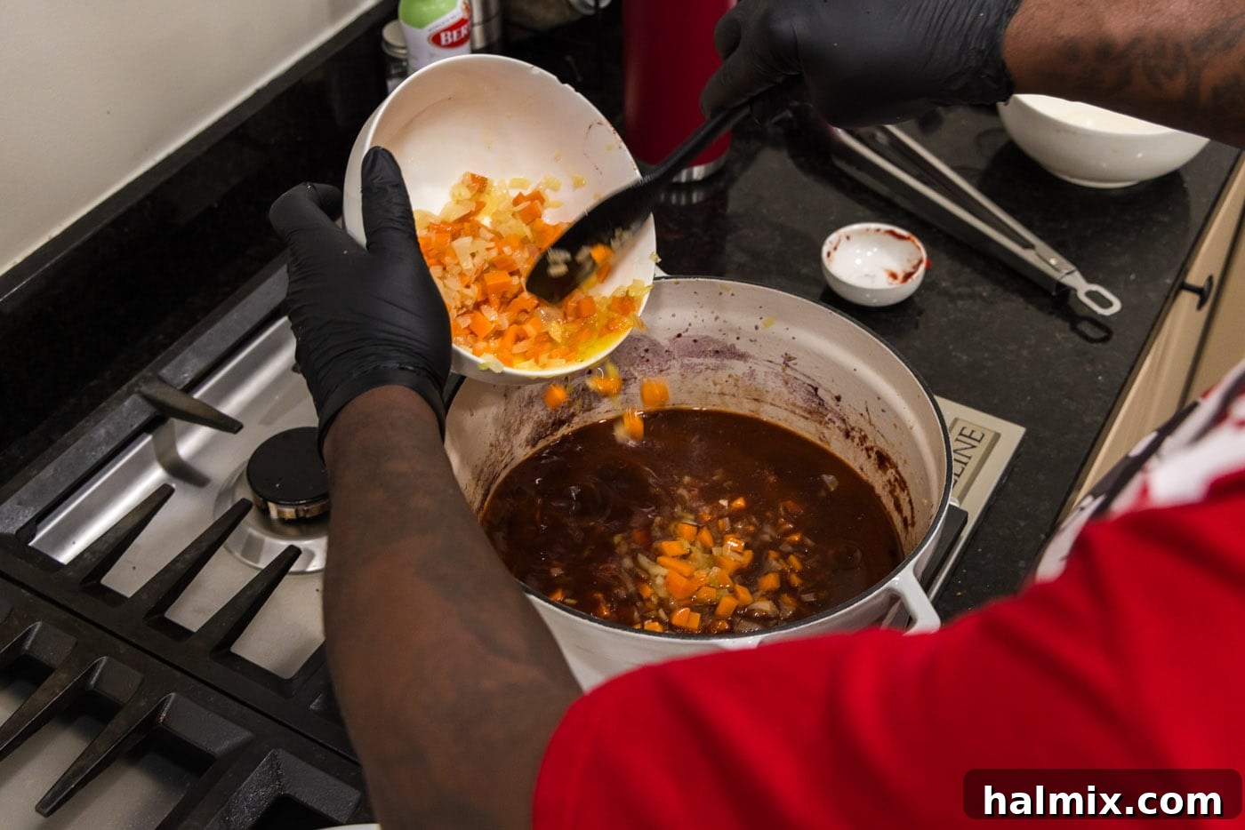 Fall-Off-The-Bone Short Ribs 13 Adding sautéed carrots and onions back to the pot, ready to join the red wine sauce.