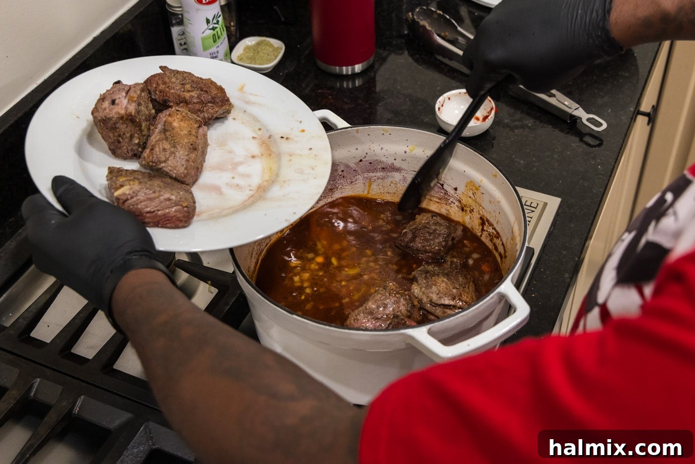 Fall-Off-The-Bone Short Ribs 14 Placing the seared short ribs into the pot with the red wine sauce and vegetables, ready for braising.