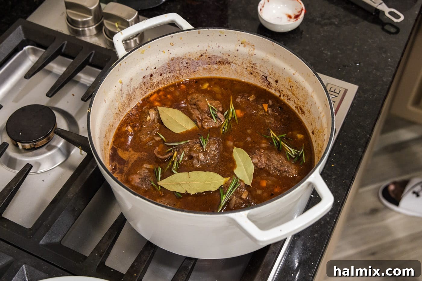 Fall-Off-The-Bone Short Ribs 15 Braised beef short ribs simmering in a rich red wine sauce, infused with fresh rosemary and bay leaves.