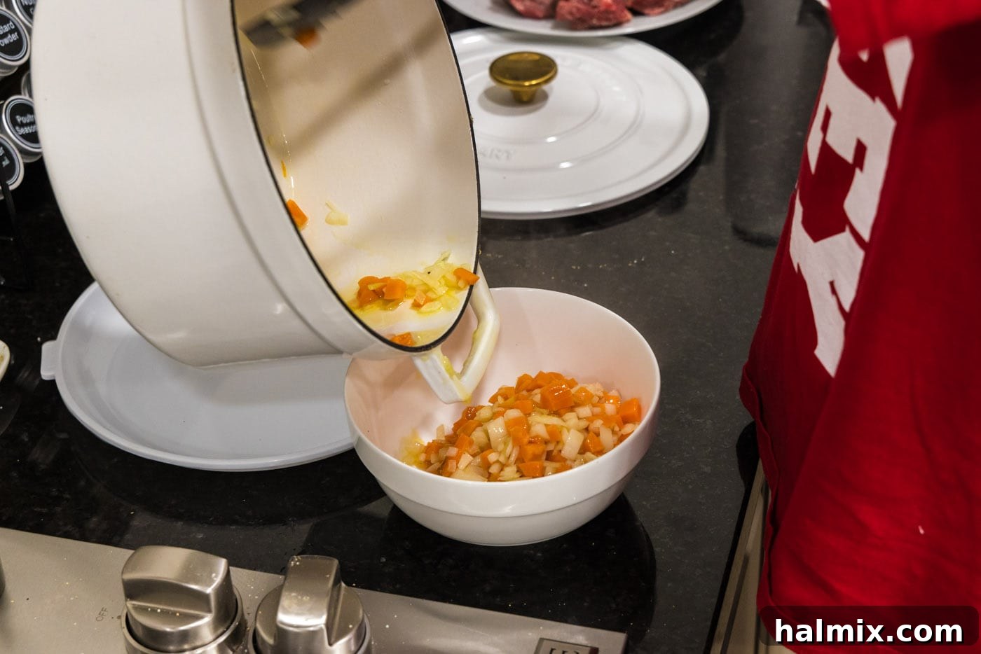 Fall-Off-The-Bone Short Ribs 7 Removing sautéed onions and carrots from the Dutch oven, leaving behind flavorful browned bits.