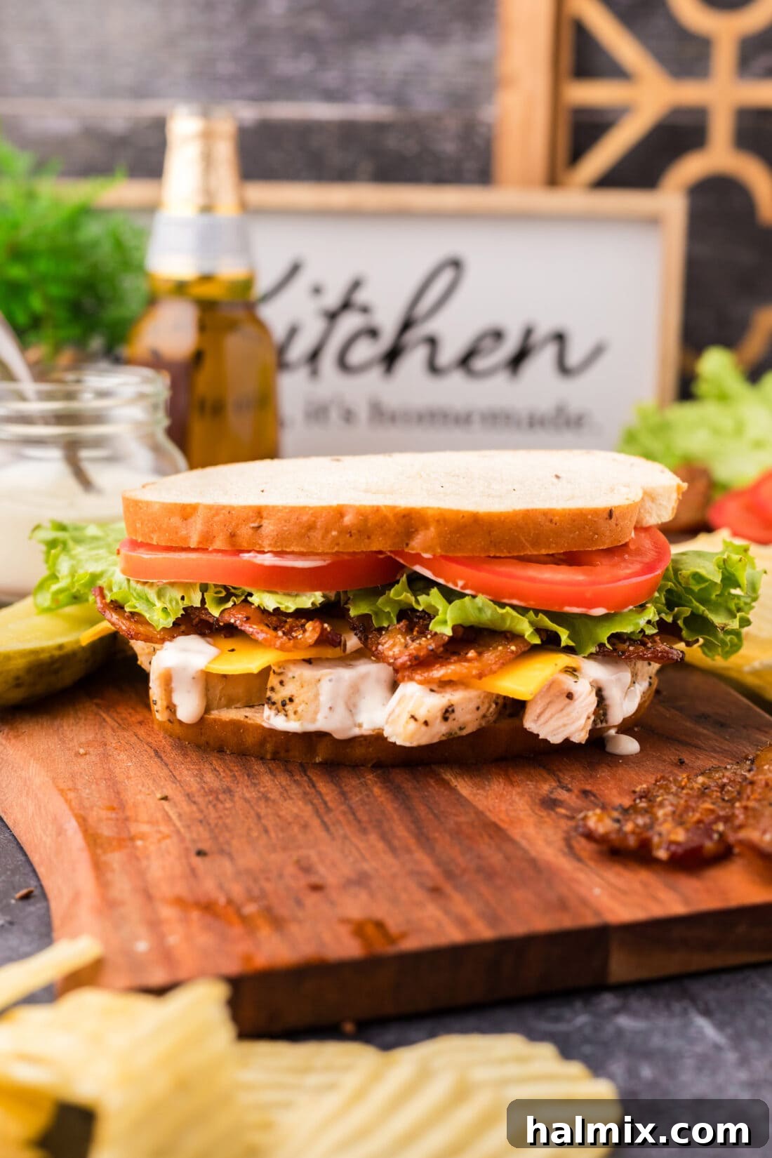 Fried Chicken Ranch Melt 3 Chicken Bacon Ranch Sandwich presented on a rustic wooden serving tray