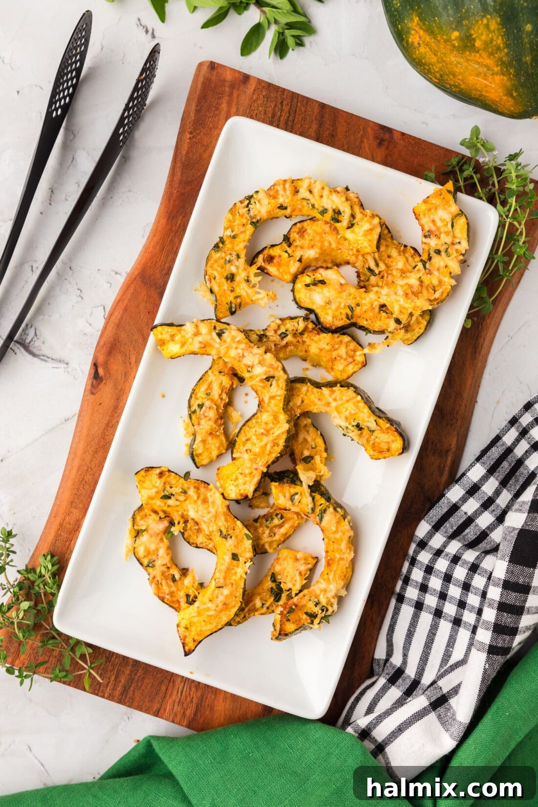 Air Fryer Acorn Squash on a platter, perfectly roasted and seasoned with parmesan and thyme.