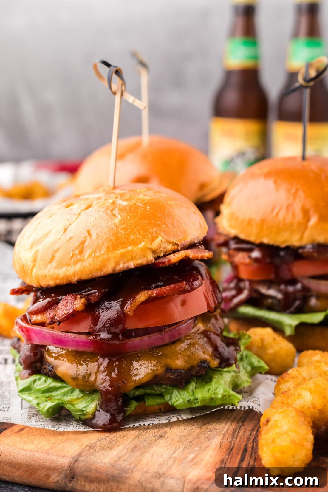BBQ Bacon Burgers on a wooden board, showcasing a ready-to-eat burger with all the fixings.