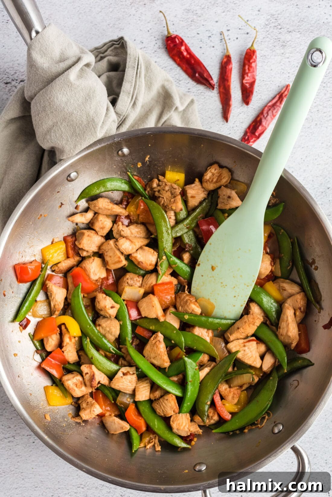 Kung Pao Chicken stir-frying in a hot wok, showcasing the vibrant ingredients.