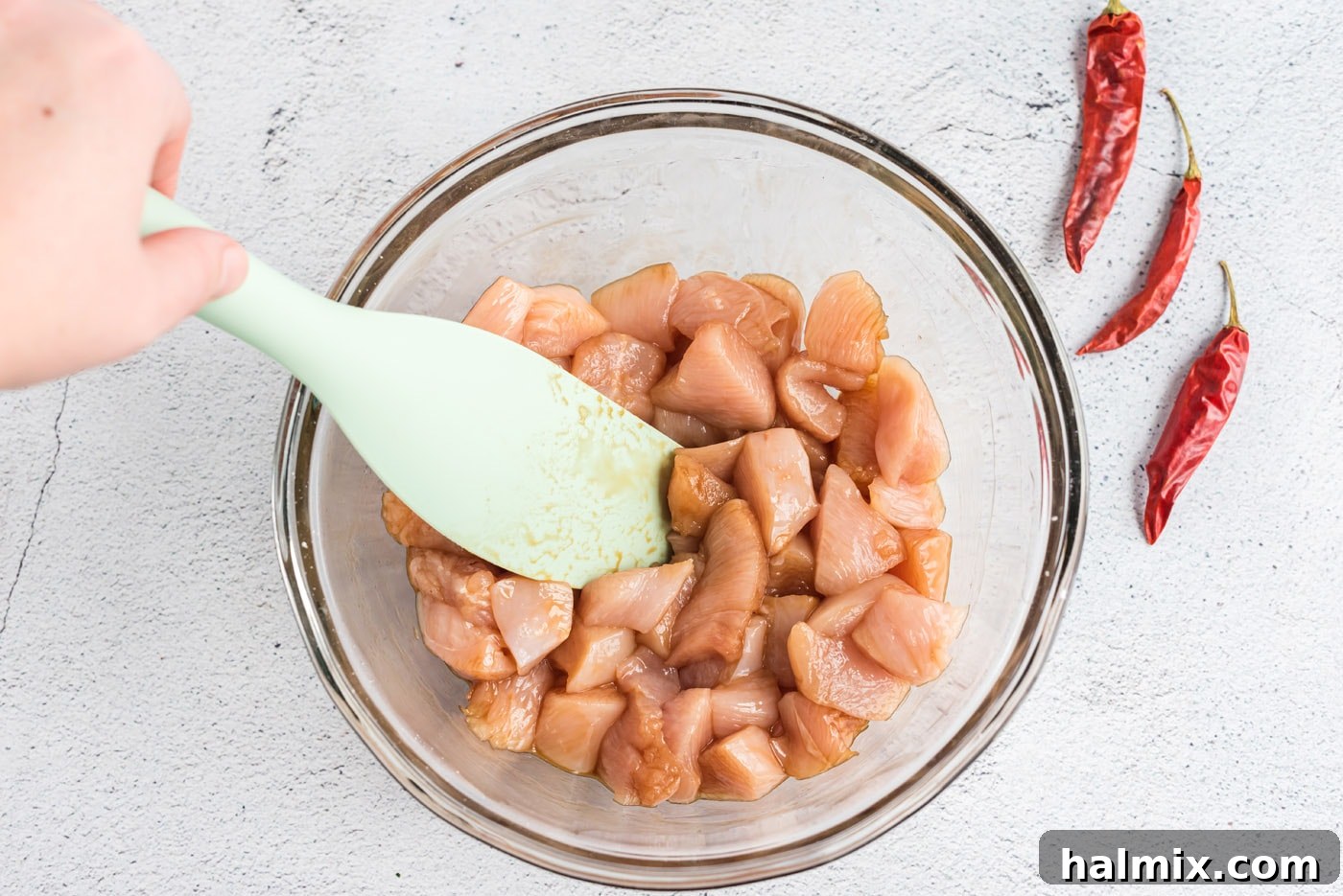 Chicken pieces marinating in soy sauce and cornstarch.