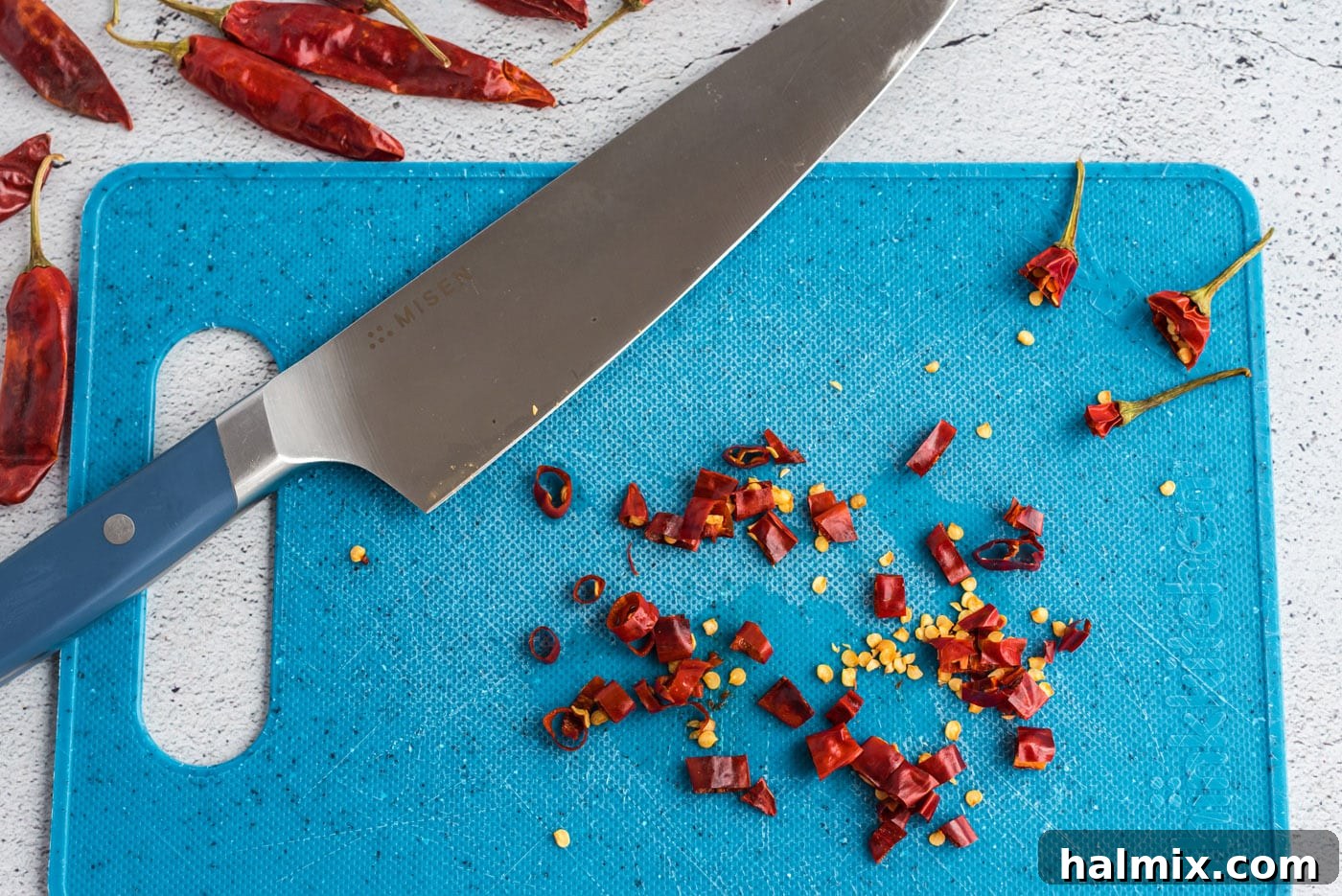 Chopped red chile peppers on a cutting board.
