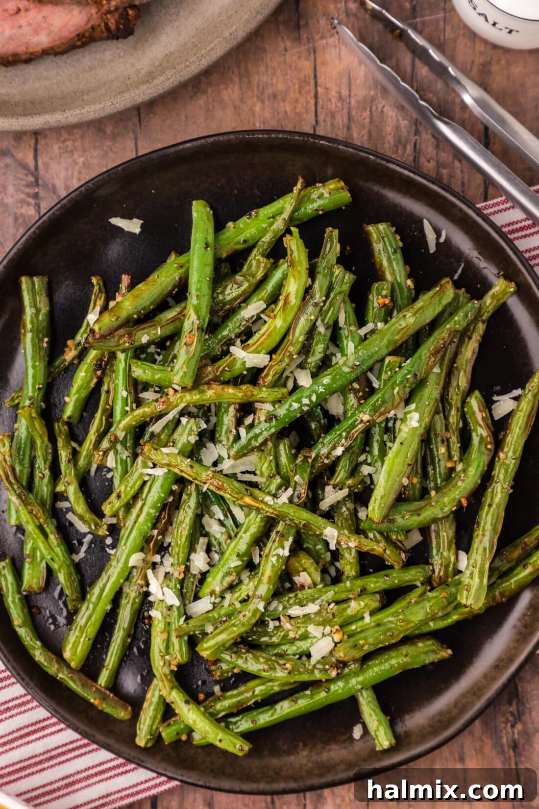 Close up photo of a plate of vibrant Air Fryer Green Beans, perfectly cooked and seasoned, ready to be enjoyed.