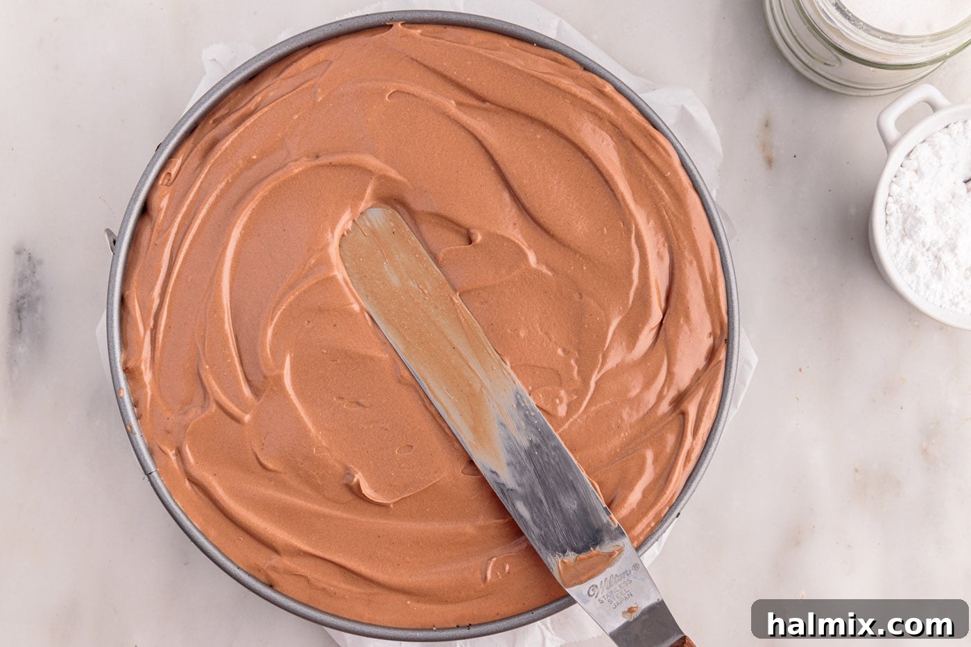 smoothing no bake chocolate cheesecake mixture in a springform pan