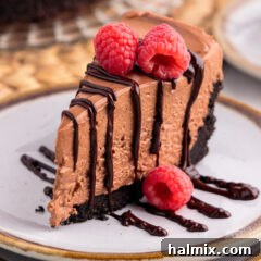 Slice of No Bake Chocolate Cheesecake on a plate drizzled with chocolate ganache