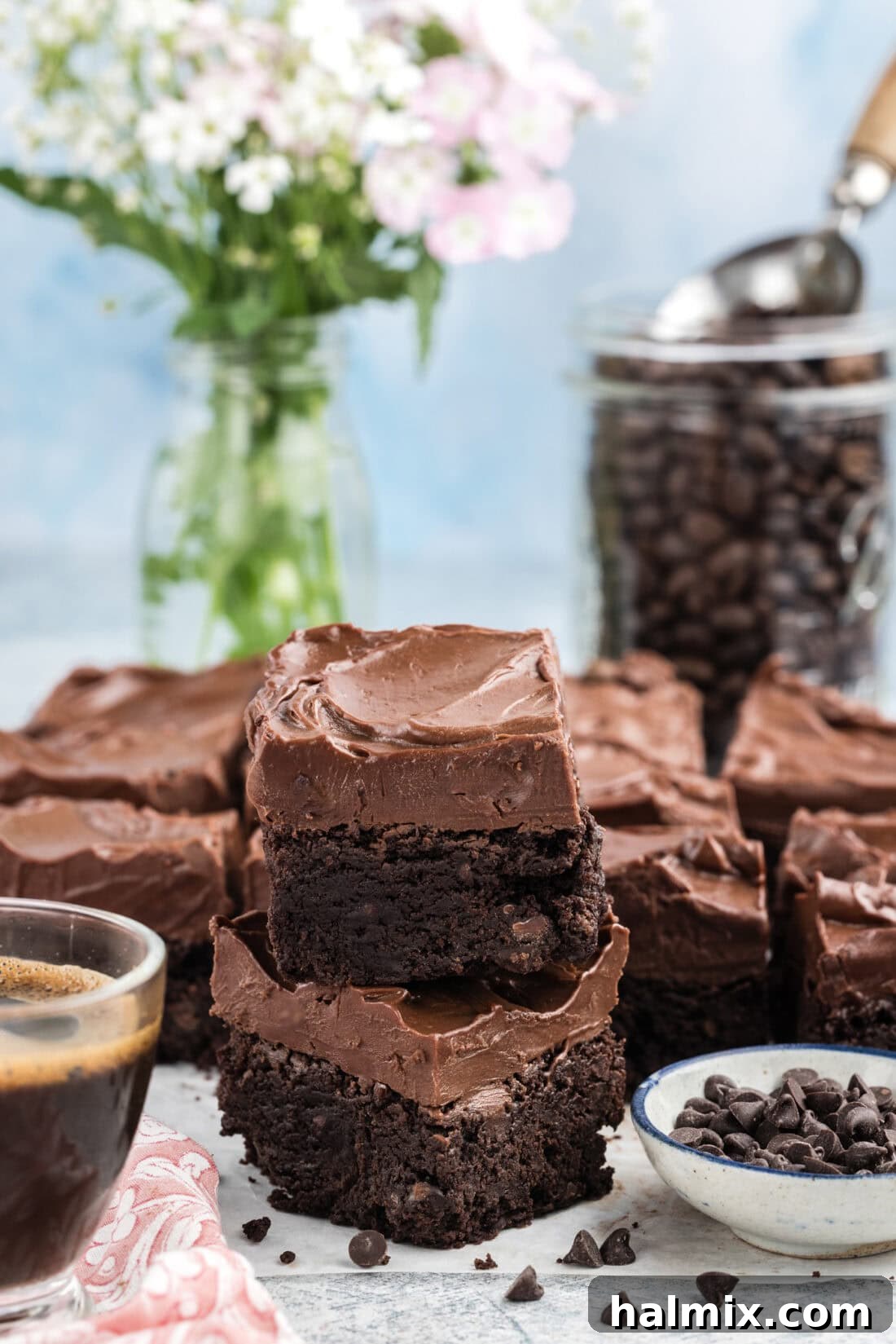 Stack of four delectable Fudge Frosted Espresso Brownies on a white surface